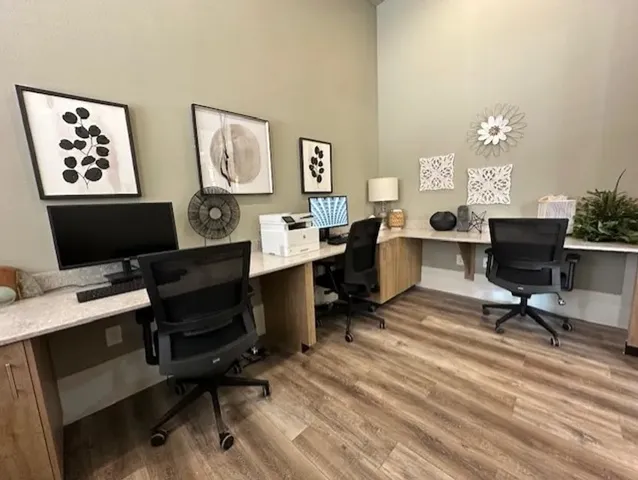 a view of a workspace with furniture and a window