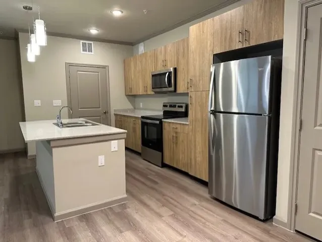a kitchen with stainless steel appliances a refrigerator stove microwave and sink