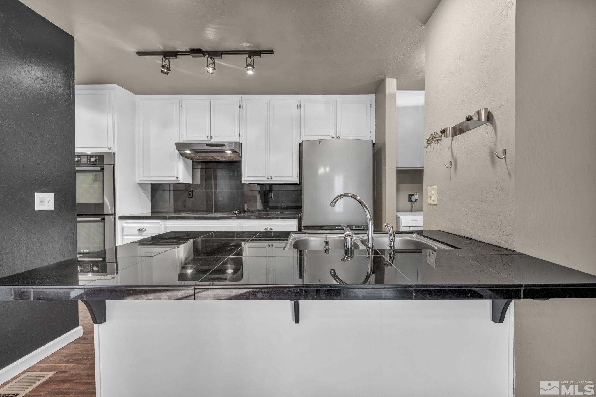 4311 Clyde Court Reno, NV 89509 - Photo 8 of 40 a kitchen with stainless steel appliances granite countertop a sink and a refrigerator
