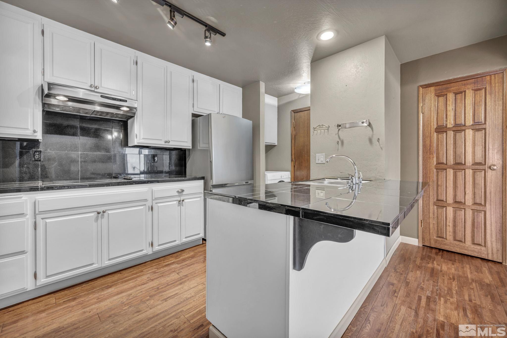 4311 Clyde Court Reno, NV 89509 - Photo 9 of 40 a large kitchen with granite countertop a sink a counter space stainless steel appliances and cabinets