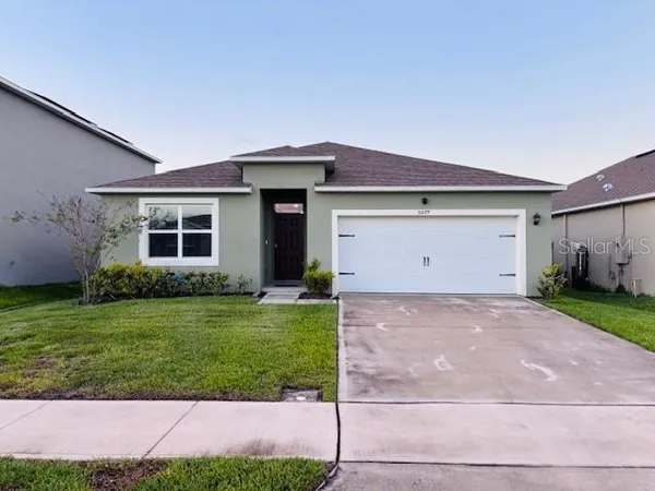 a front view of a house with a yard and garage