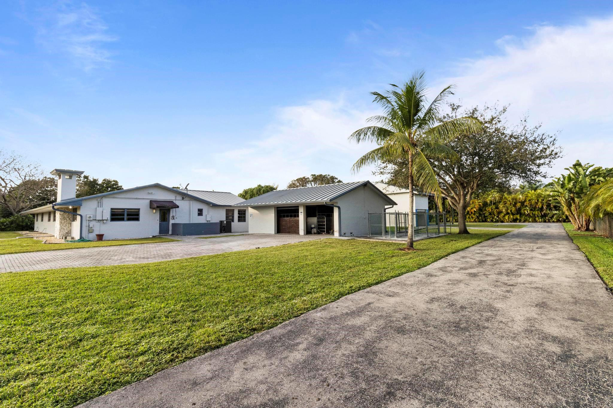 17781 Southwest 52nd Court Southwest Ranches, FL 33331 - Photo 4 of 39 a front view of a house with a yard and garage