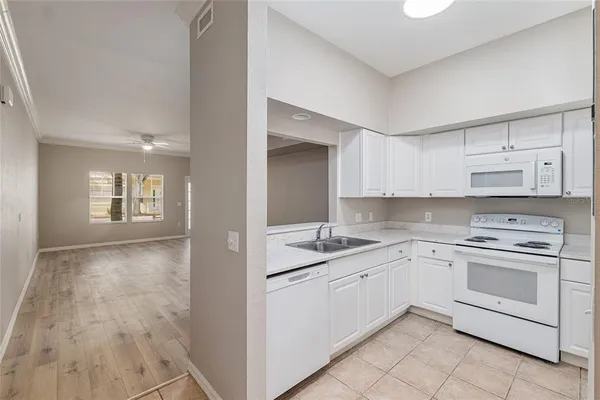 a kitchen with white cabinets appliances and sink
