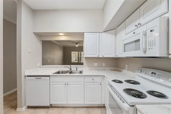 a kitchen with white cabinets and white appliances