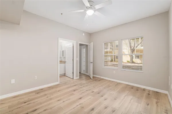 an empty room with wooden floor and windows