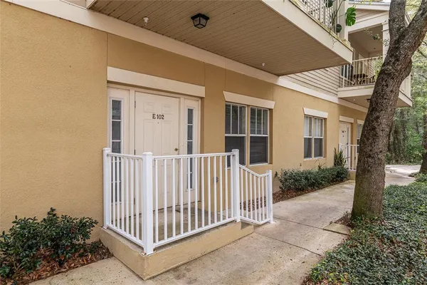 a view of a house with a small yard and wooden fence