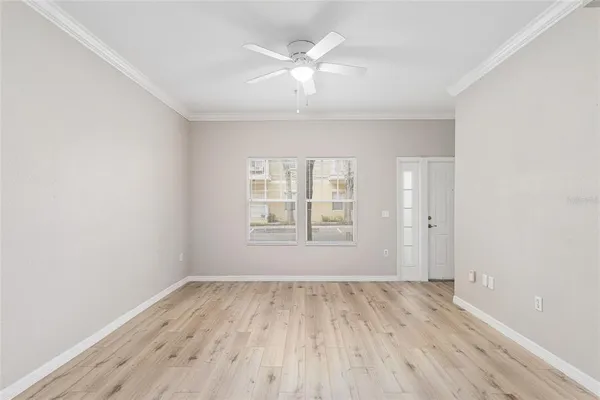 an empty room with wooden floor and windows