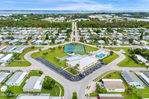 an aerial view of a house with a yard and lake view