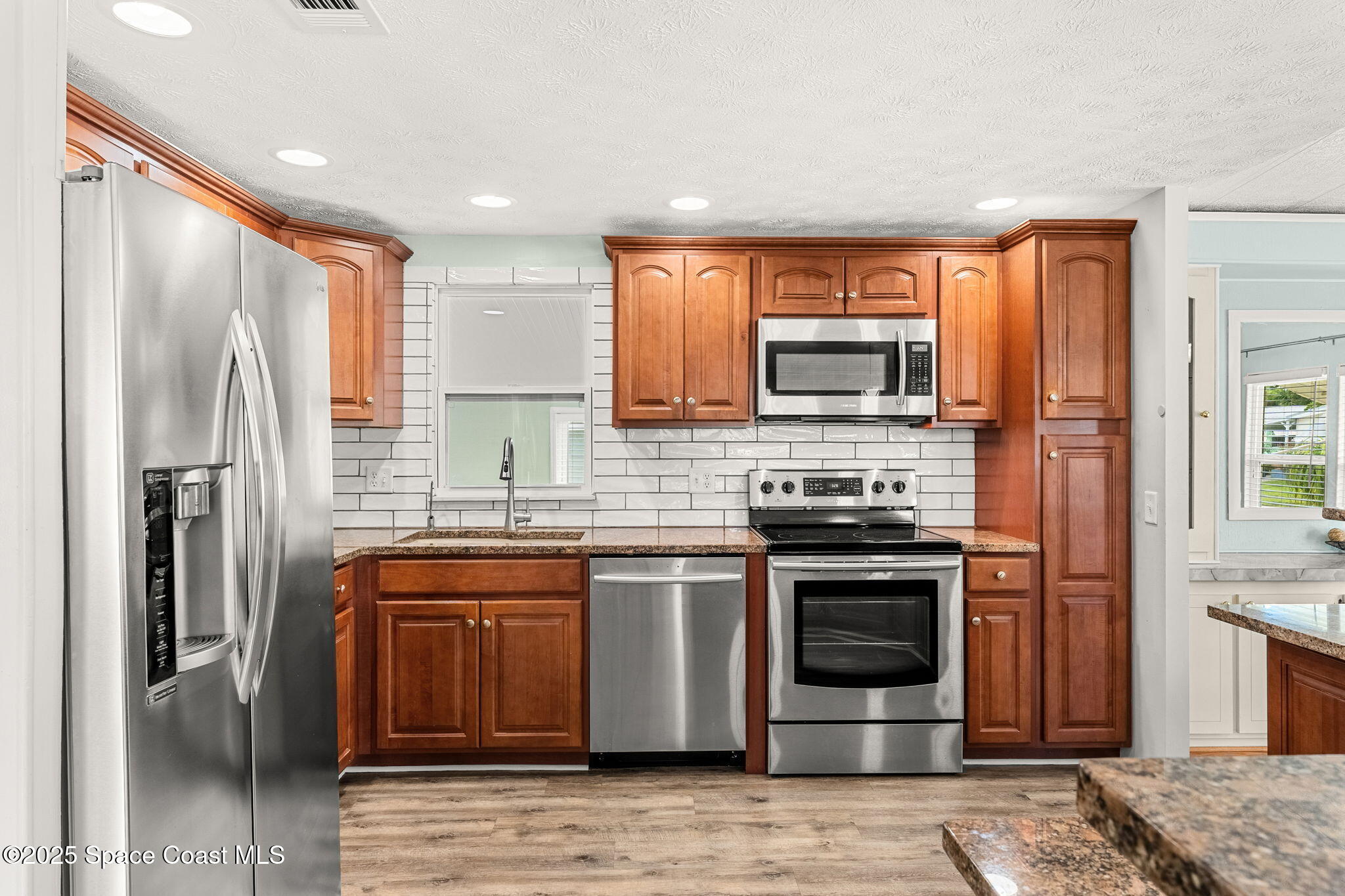 1885 Mango Street Northeast Palm Bay, FL 32905 - Photo 9 of 36 a kitchen with stainless steel appliances granite countertop a stove a sink and a refrigerator