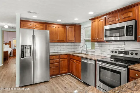 a kitchen with stainless steel appliances granite countertop a stove microwave and refrigerator