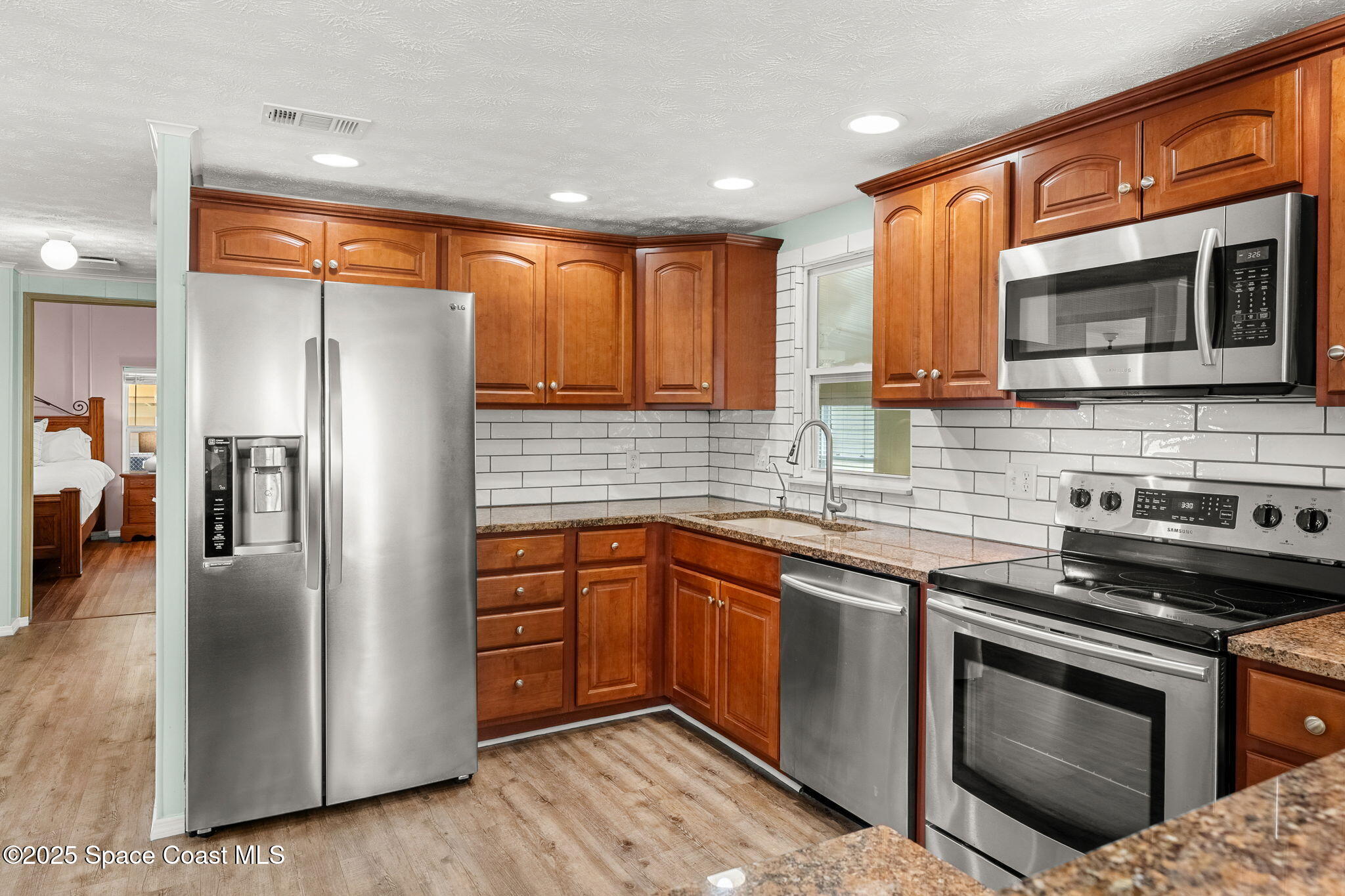 1885 Mango Street Northeast Palm Bay, FL 32905 - Photo 10 of 36 a kitchen with stainless steel appliances granite countertop a stove microwave and refrigerator