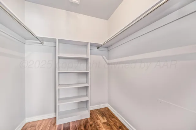 a view of walk in closet with empty racks