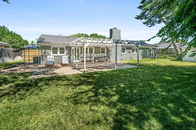 a front view of a house with a garden and lake view