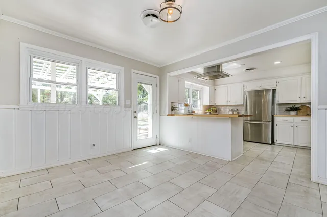 a kitchen with white cabinets and window