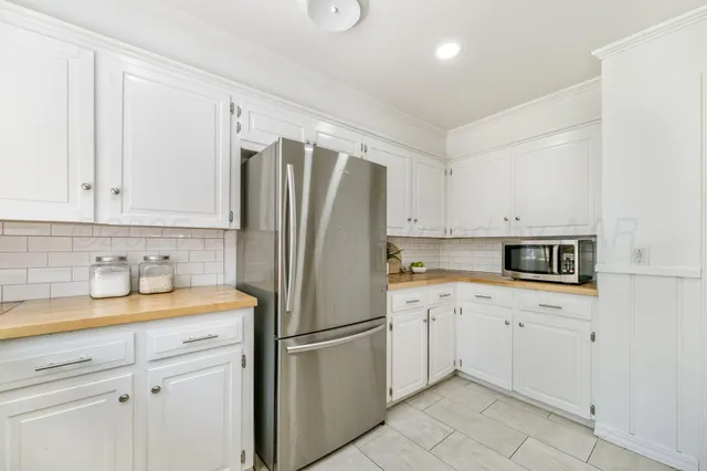 a kitchen with a refrigerator sink and cabinets