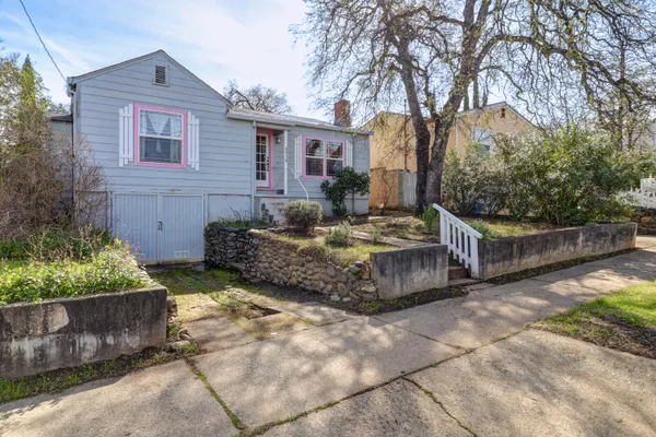 a view of a house with wooden fence in front of it