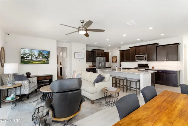 a living room with stainless steel appliances kitchen island furniture and a view of kitchen