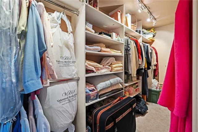 a view of walk in closet with clothes and shoes