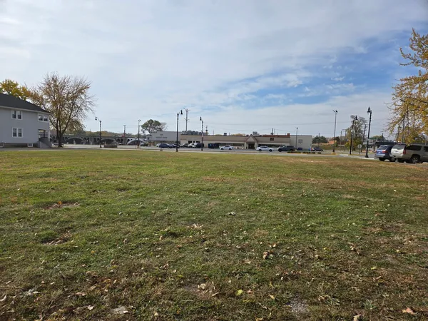 a view of a field with an trees in front of it
