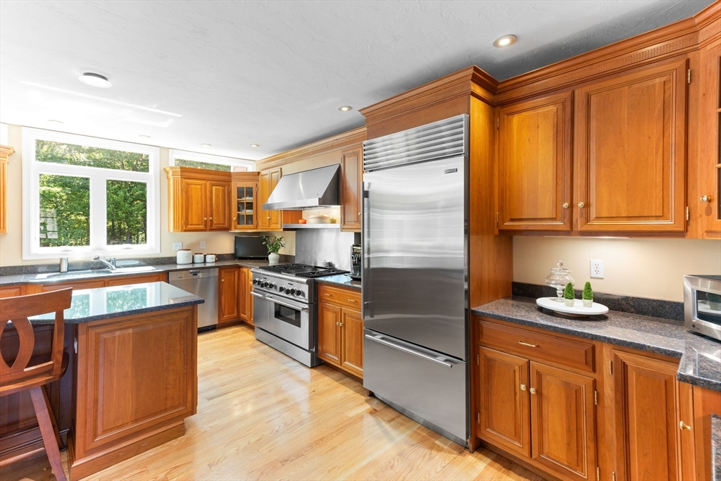 5 Linden Glen Road Canton, MA 02021 - Photo 15 of 42 a kitchen with stainless steel appliances granite countertop wooden cabinets a sink a stove a refrigerator and blue cabinets