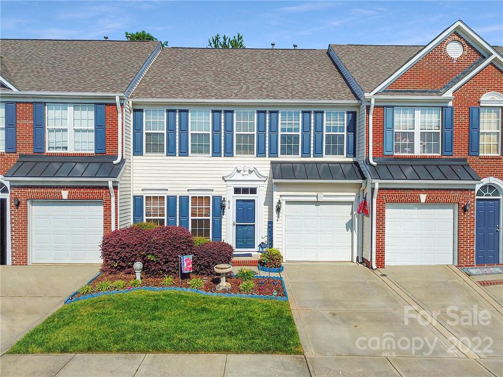 a front view of a house with garden and garage