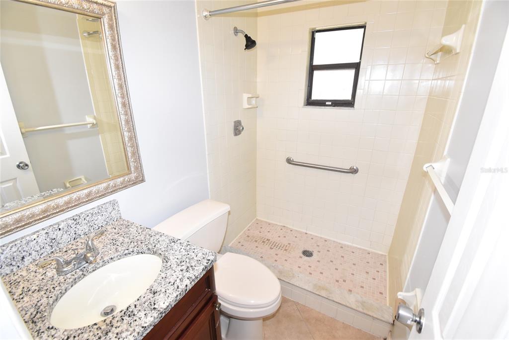 7615 Karen Drive Port Richey, FL 34668 - Photo 13 of 24 a bathroom with a granite countertop sink toilet and shower