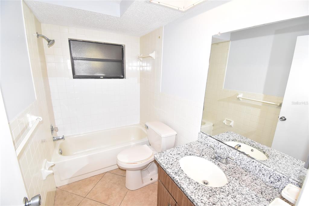 7615 Karen Drive Port Richey, FL 34668 - Photo 17 of 24 a bathroom with a granite countertop toilet sink and mirror