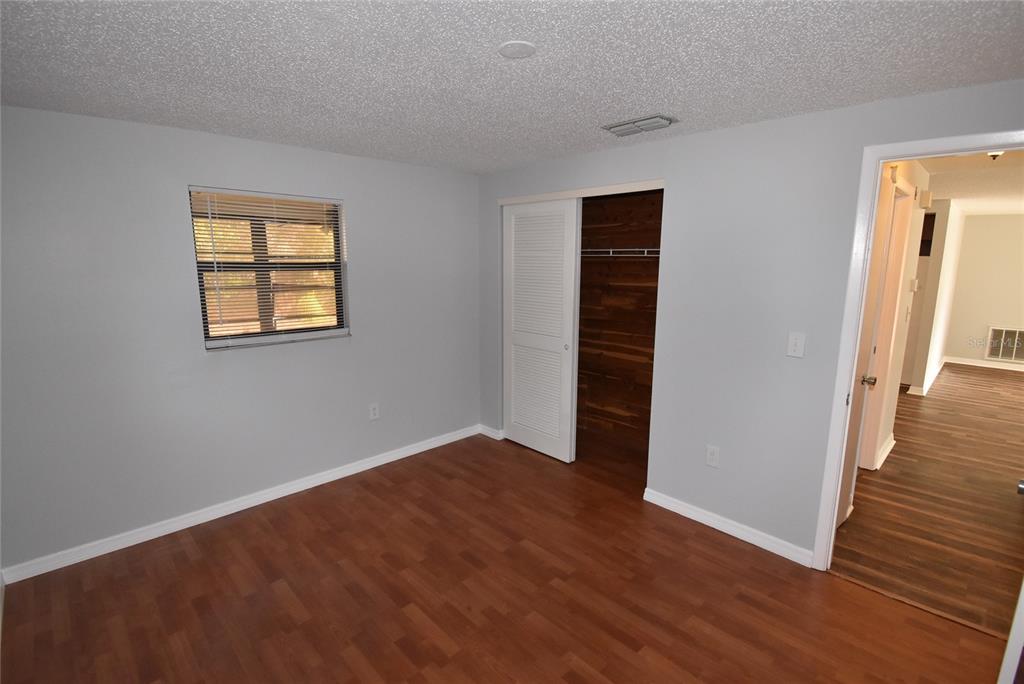 7615 Karen Drive Port Richey, FL 34668 - Photo 19 of 24 an empty room with wooden floor closet and windows
