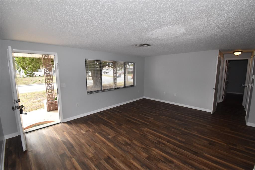 7615 Karen Drive Port Richey, FL 34668 - Photo 2 of 24 an empty room with wooden floor and windows