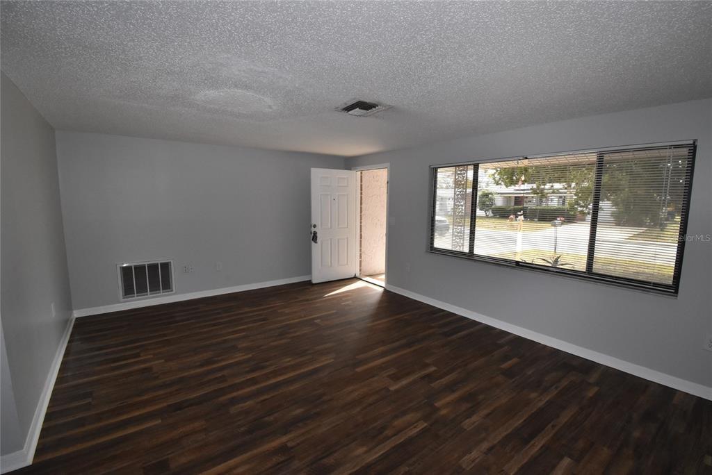 7615 Karen Drive Port Richey, FL 34668 - Photo 4 of 24 a view of an empty room with wooden floor and a window