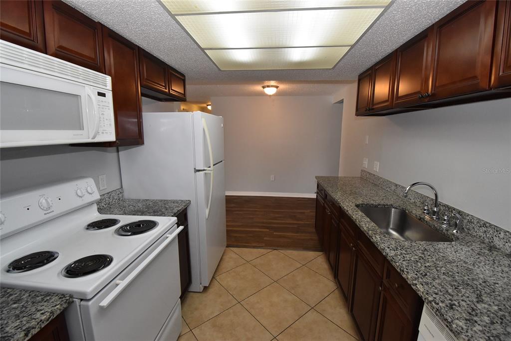 7615 Karen Drive Port Richey, FL 34668 - Photo 5 of 24 a kitchen that has a sink a stove and cabinets