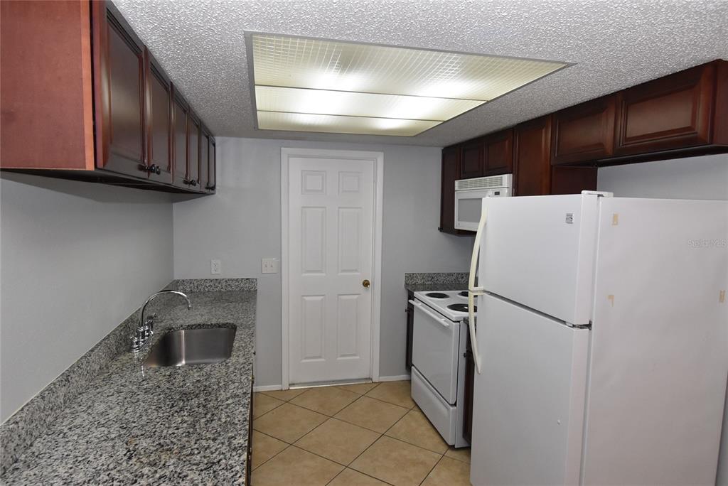 7615 Karen Drive Port Richey, FL 34668 - Photo 6 of 24 a kitchen with stainless steel appliances granite countertop a refrigerator and a sink