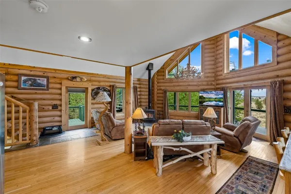 a living room with fireplace furniture and a large window