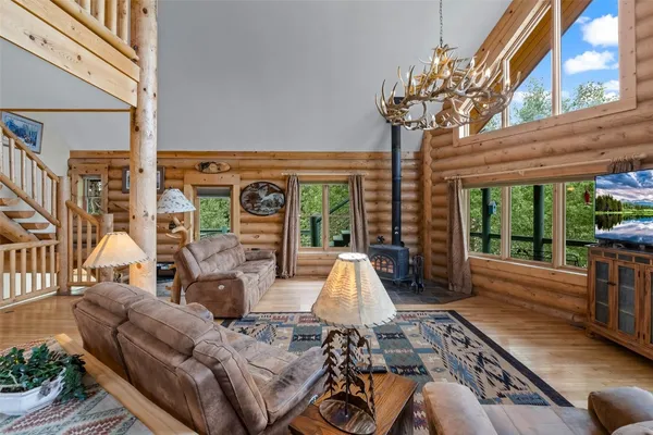 a living room with furniture fireplace and large windows