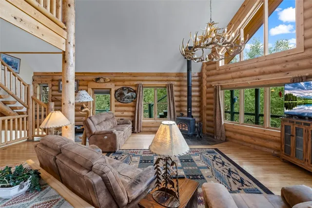 a living room with furniture fireplace and large windows