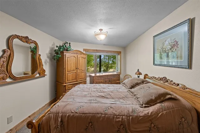 a bedroom with a bed mirror and window