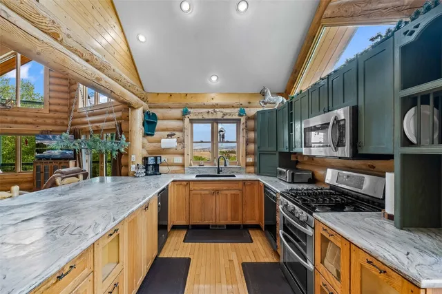a large kitchen with stainless steel appliances granite countertop a stove and a wooden cabinets