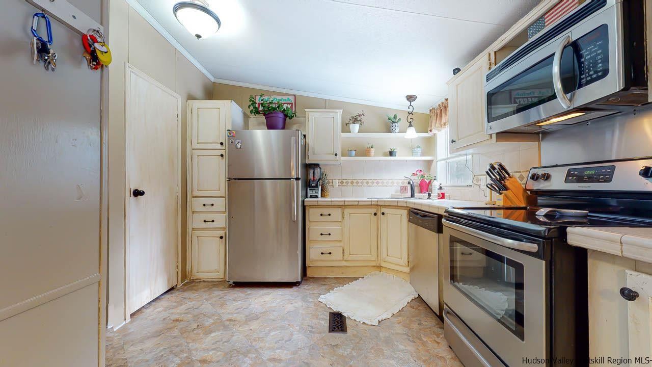 271 Scarawan Road Stone Ridge, NY 12484 - Photo 8 of 27 a kitchen with stainless steel appliances a refrigerator sink and cabinets