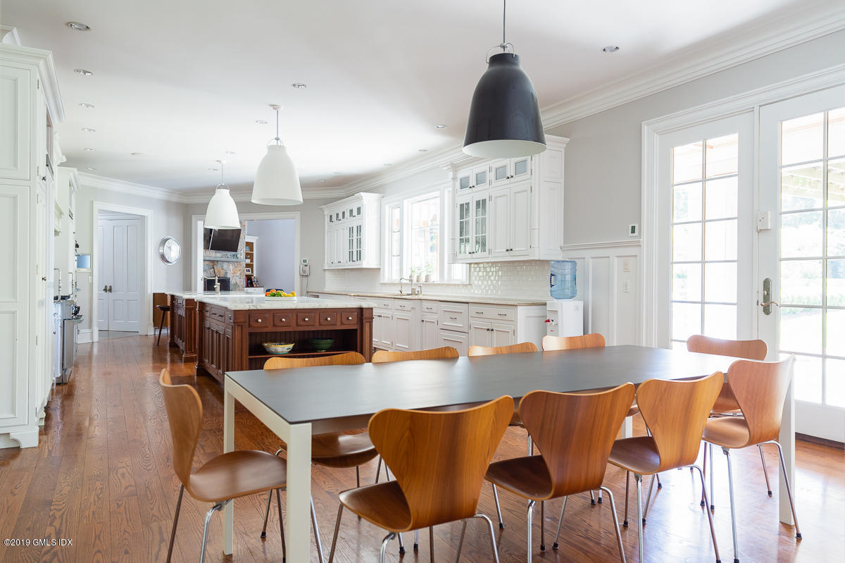 170 Old Mill Road Greenwich, CT 06831 - Photo 15 of 42 a kitchen with stainless steel appliances kitchen island granite countertop a table chairs and a refrigerator