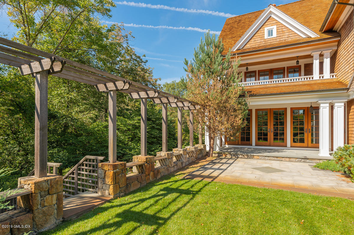 170 Old Mill Road Greenwich, CT 06831 - Photo 36 of 42 front view of a house with a chairs and table in the patio