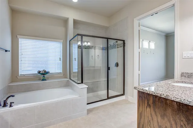 a bathroom with a granite countertop tub shower and sink
