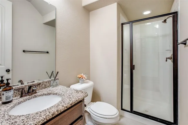 a bathroom with a granite countertop sink toilet and shower