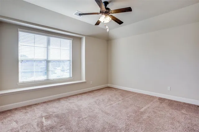 a view of a livingroom with a ceiling fan and window