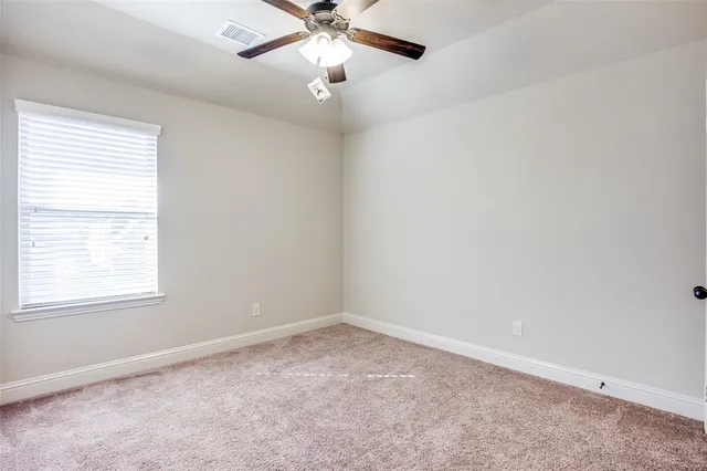 an empty room with a window and a fan