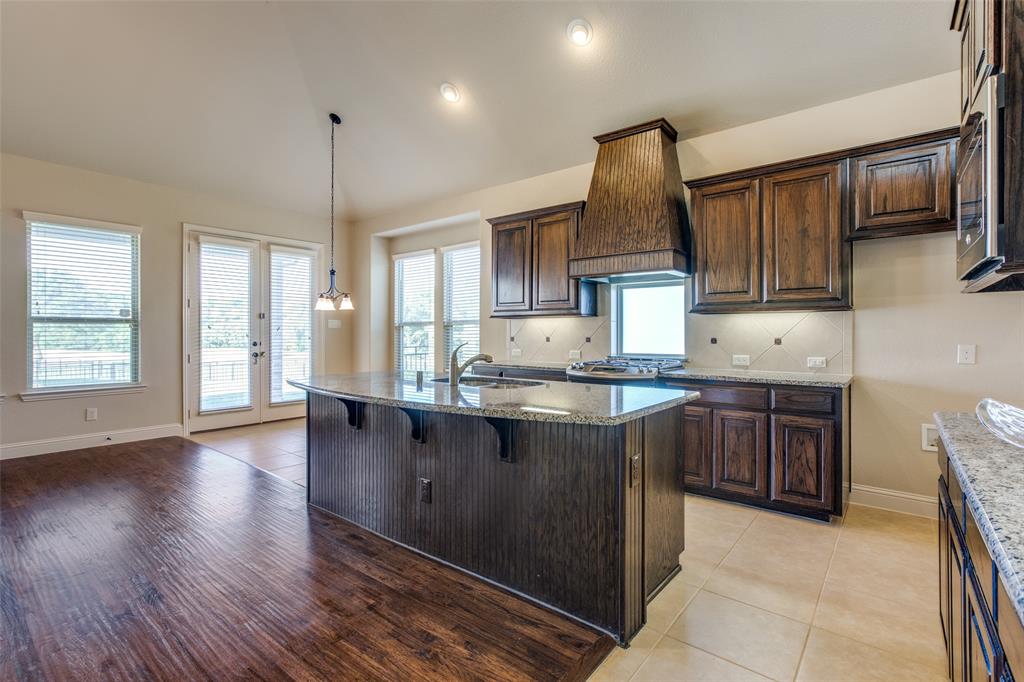 503 Hemlock Court Wylie, TX 75098 - Photo 7 of 35 a kitchen with stainless steel appliances granite countertop a sink stove and wooden cabinets