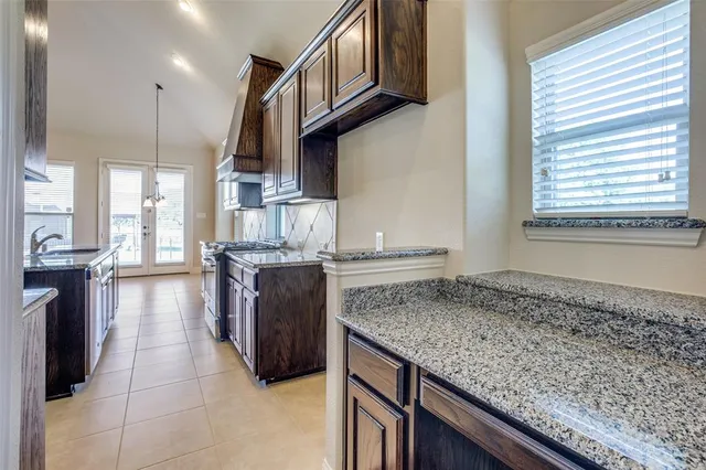 a kitchen with granite countertop a stove a sink and a oven
