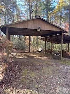 a view of a backyard with wooden fence and large trees