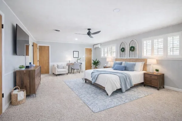 a spacious bedroom with a bed and glass couch