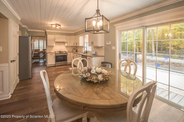 a dining room with furniture a chandelier and wooden floor