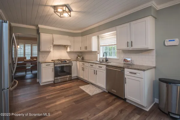 a kitchen with granite countertop a stove top oven sink and cabinets